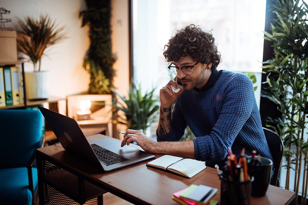 Man on phone looking at computer