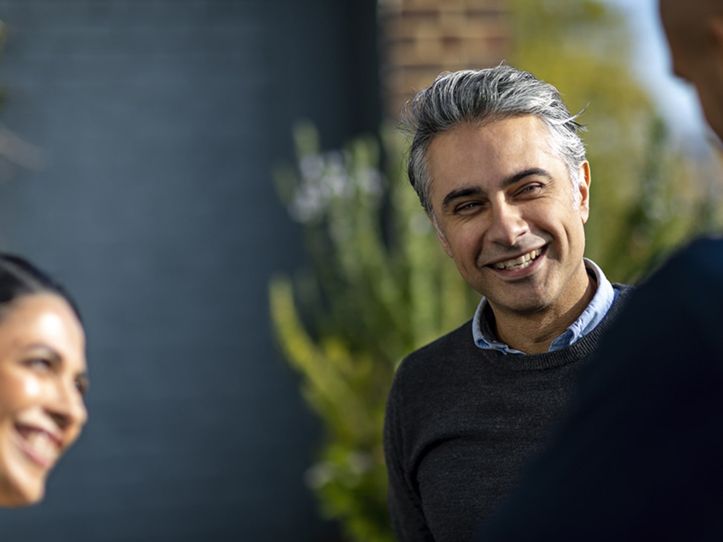 man smiling talking to coworkers