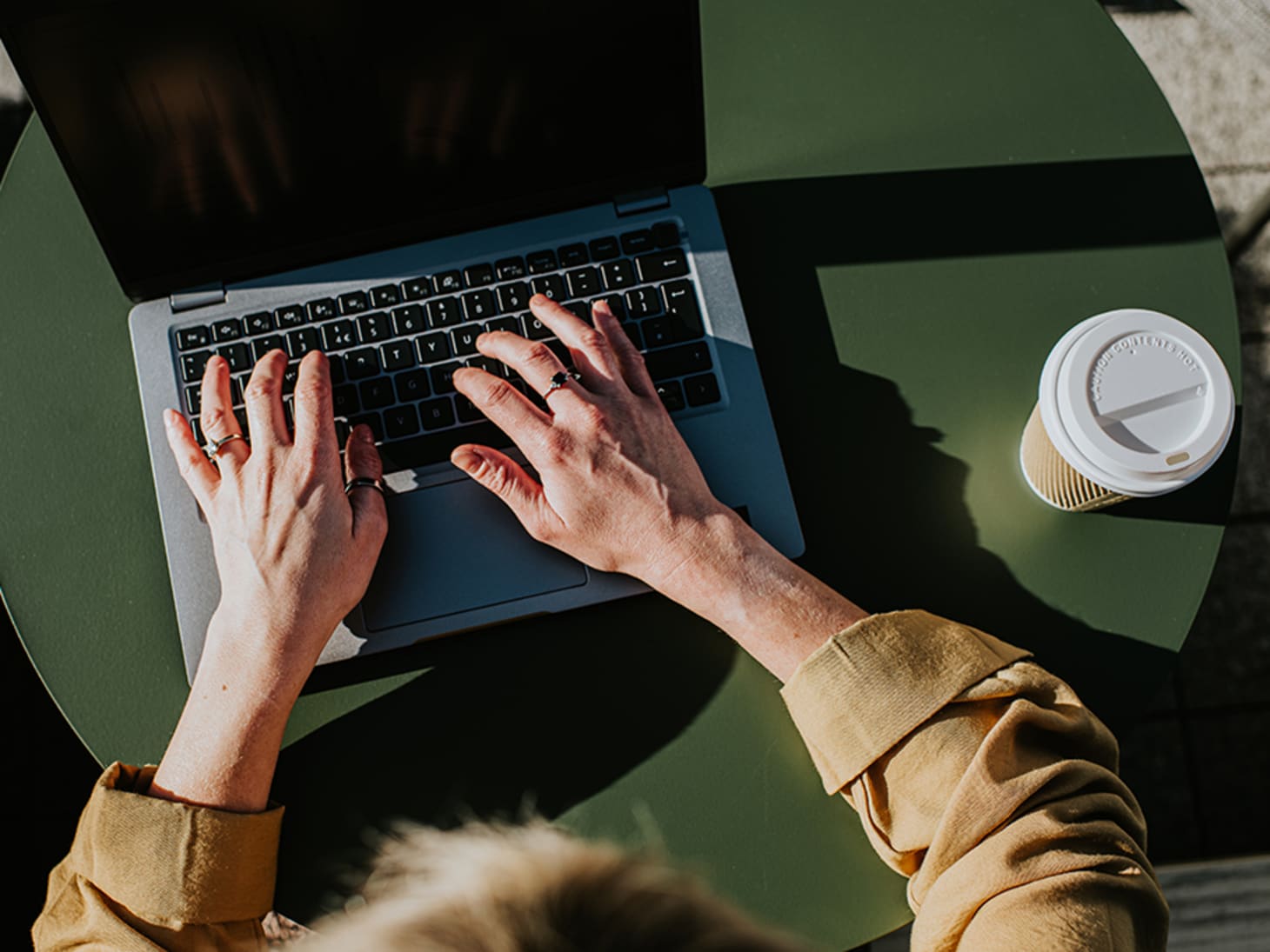 shot of hands typing on a laptop, from above