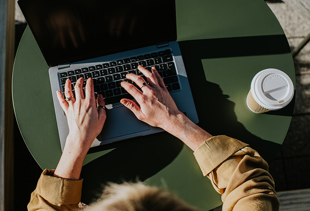 person's hands on a laptop keyboard