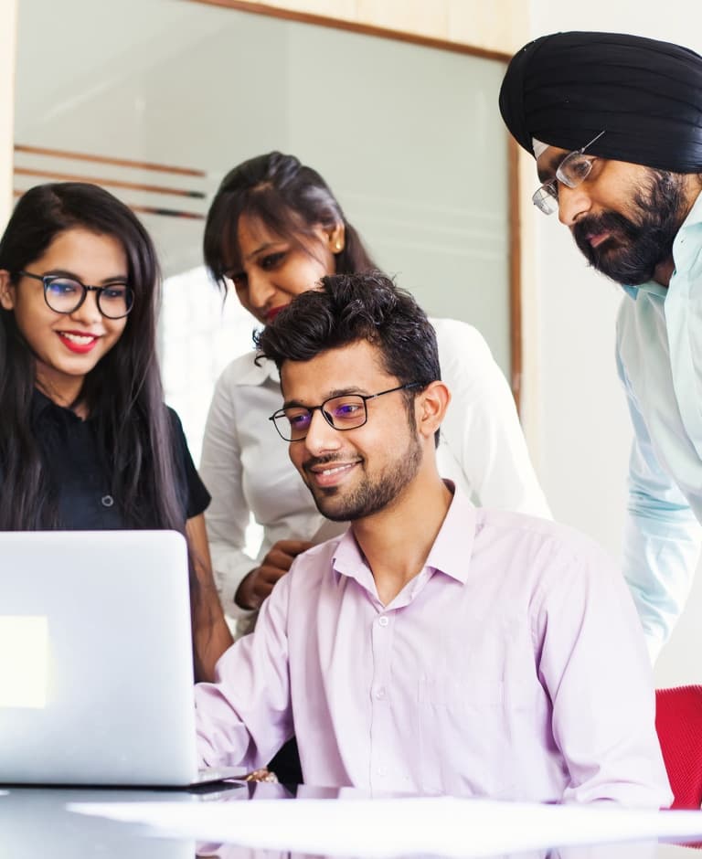 Team working together standing around one laptop