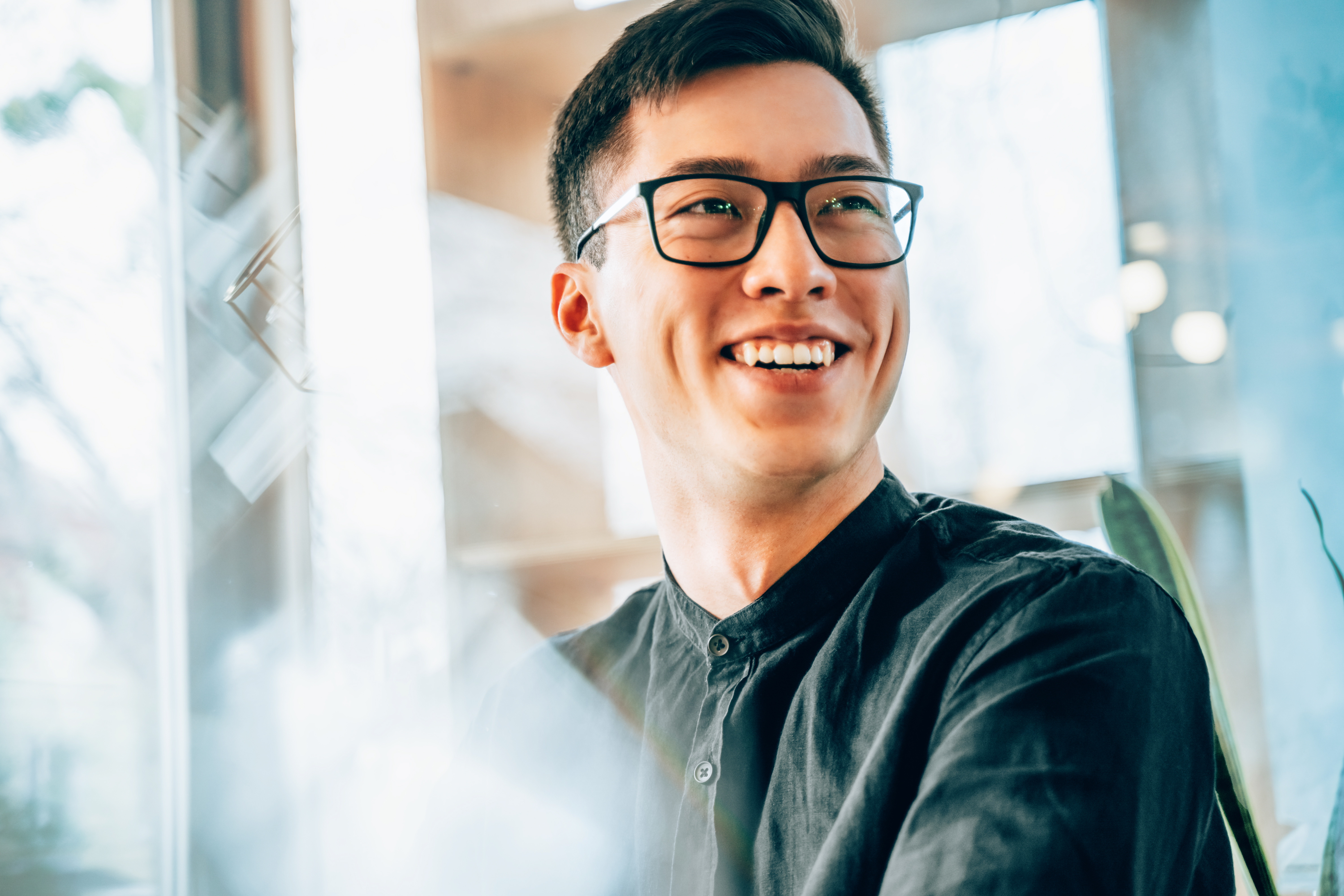 smiling man in glasses with short dark hair 