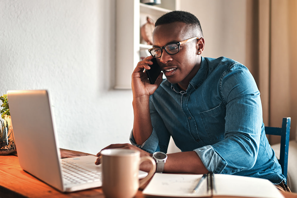 black man in glasses working at his computer