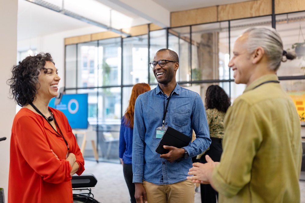 three diverse coworkers laughing in the office
