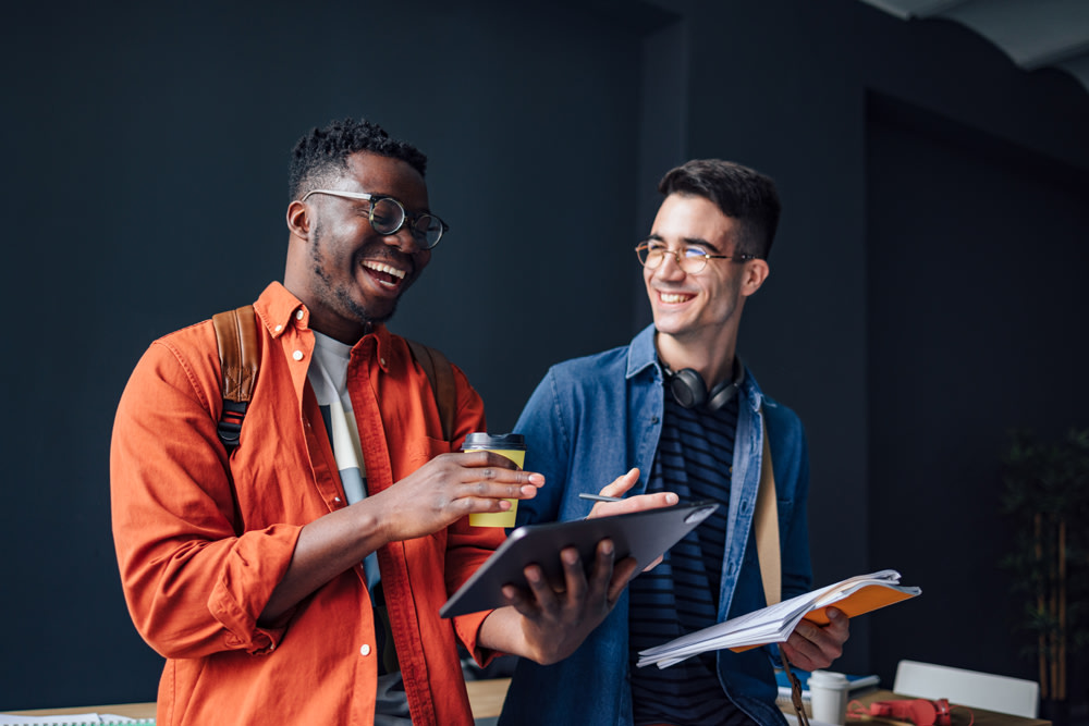 two corowkers talking happily over project notes