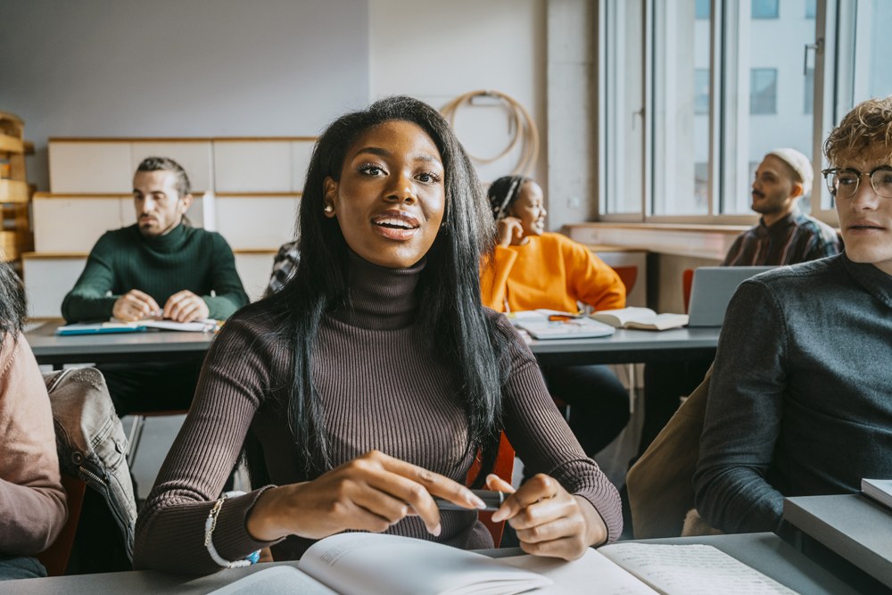 girl with a bunch of students asking a question