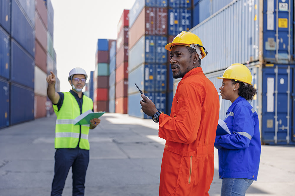 Employees standing between shipping containers