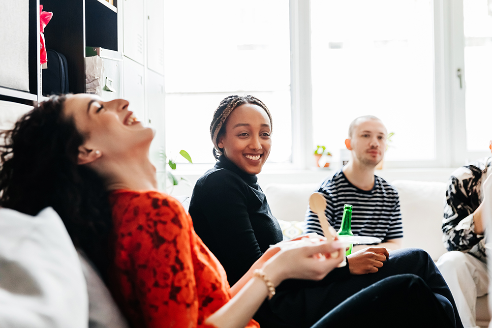 woman laughing in room working with team at office