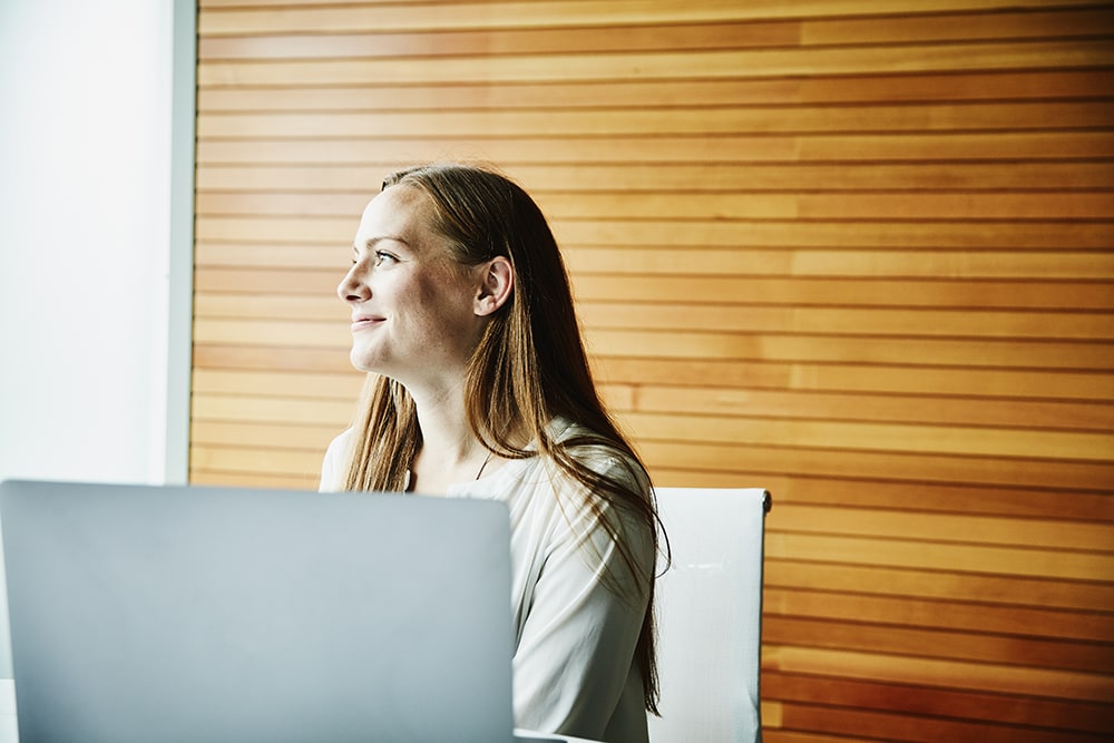 Woman in office sitting behind laptop