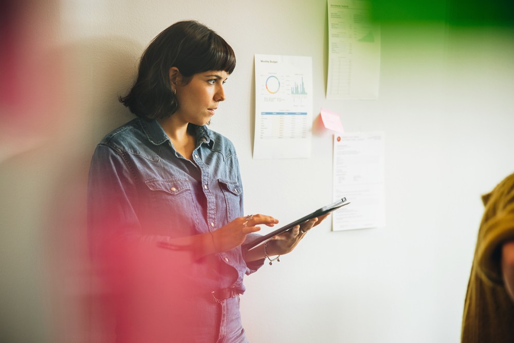 Woman standing against the wall with tablet